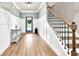 Grand foyer features wainscoting detail, hardwood floors, and staircase with iron railings at 2980 Beards Rd, Buford, GA 30518