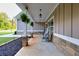 Charming front porch with rocking chairs, hanging ferns, and stone detailing, creating a cozy and inviting entrance at 2980 Beards Rd, Buford, GA 30518