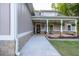 Inviting front porch with stone accents, stylish seating, and hanging plants, perfect for relaxing and enjoying the outdoors at 2980 Beards Rd, Buford, GA 30518