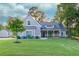 Beautifully landscaped front yard with lush green grass, flowering hydrangeas, and a cozy porch on a craftsman style home at 2980 Beards Rd, Buford, GA 30518