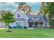 Charming home with a beautiful lawn, complemented by flowering shrubs and a welcoming front porch with stone accents at 2980 Beards Rd, Buford, GA 30518