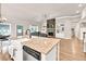 Farmhouse sink and stainless steel dishwasher, adjacent to the kitchen island, enhance the living space at 2980 Beards Rd, Buford, GA 30518