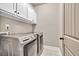 Bright laundry room featuring modern appliances and ample cabinet space for storage at 2980 Beards Rd, Buford, GA 30518
