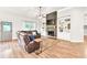 Open-concept living room with a stone fireplace, built-in shelves, and a brown leather reclining sofa at 2980 Beards Rd, Buford, GA 30518