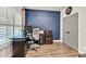 Well-lit home office featuring a statement accent wall, modern furnishings, and wood flooring at 2980 Beards Rd, Buford, GA 30518