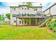 Back exterior view showcasing a large wooden deck, lush lawn, and mature trees at 3060 Mccannon Mill Dr, Dacula, GA 30019