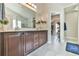 Bathroom featuring double vanity with wood cabinets and a walk-in closet for ample storage at 3060 Mccannon Mill Dr, Dacula, GA 30019