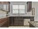 Kitchen featuring dark wood cabinetry, stainless steel dishwasher, and beautiful granite countertops at 3060 Mccannon Mill Dr, Dacula, GA 30019