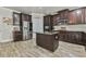 Beautiful kitchen features dark cabinets, granite counters, stainless appliances, and an island in the middle at 3060 Mccannon Mill Dr, Dacula, GA 30019