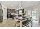 Bright kitchen with wood floors, dark cabinets, stainless steel appliances, and breakfast table near the doors to the deck at 3060 Mccannon Mill Dr, Dacula, GA 30019