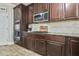 Close-up view of the dark wood cabinetry, stainless steel microwave, and granite countertops at 3060 Mccannon Mill Dr, Dacula, GA 30019