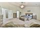 Well-lit main bedroom with a large bed, upholstered bench, nightstands and two entrances to the bathroom at 3060 Mccannon Mill Dr, Dacula, GA 30019