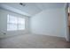 Bright bedroom with soft carpeting, a vaulted ceiling, and a large window allowing for lots of natural light at 2326 Bigwood Trl, Atlanta, GA 30349