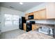 This kitchen has black appliances, wood cabinets, lots of light, and a double sink at 2326 Bigwood Trl, Atlanta, GA 30349