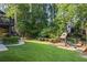 Spacious backyard featuring lush lawn, a playground, and mature trees, perfect for outdoor enjoyment at 2517 Stone Manor Dr, Buford, GA 30519