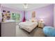 A purple bedroom with natural light, carpet floors, and white trim at 2517 Stone Manor Dr, Buford, GA 30519
