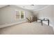 A large bonus room with carpeted floors, natural light, and vaulted ceilings at 2517 Stone Manor Dr, Buford, GA 30519
