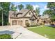 Elegant brick home with a three-car garage and expansive driveway at 2517 Stone Manor Dr, Buford, GA 30519