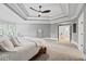 Large main bedroom featuring tray ceiling, plush carpet, and view into the ensuite bath and walk-in closet at 2517 Stone Manor Dr, Buford, GA 30519