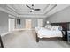 Bright main bedroom with tray ceiling, carpet flooring, and access to the ensuite bathroom at 2517 Stone Manor Dr, Buford, GA 30519