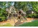 A backyard playground with a slide and swingset sits on a mulch bed, surrounded by trees and greenery at 2517 Stone Manor Dr, Buford, GA 30519