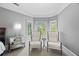 Cozy sitting area with three windows, neutral walls and trim, and a mirrored dresser at 2517 Stone Manor Dr, Buford, GA 30519