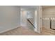 Upstairs hallway leading to laundry room featuring white appliances and wood-look flooring at 329 Heavenly Hollow Pl, Mcdonough, GA 30253