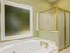 Well-lit primary bathroom featuring a tub and separate glass-enclosed shower at 3648 Clark Hill Way, Buford, GA 30519