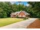 Brick home with driveway surrounded by lush trees, offering privacy and curb appeal at 3648 Clark Hill Way, Buford, GA 30519