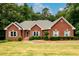 Charming brick home with a well-manicured lawn, beautiful landscaping, and classic gray shutters at 3648 Clark Hill Way, Buford, GA 30519