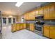 Spacious kitchen featuring stainless steel appliances, tile flooring, and light wood cabinetry at 3648 Clark Hill Way, Buford, GA 30519