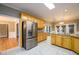 Bright kitchen with stainless steel refrigerator, light wood cabinets, and tile flooring at 3648 Clark Hill Way, Buford, GA 30519
