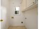 Bright laundry room offers tile floors and overhead cabinets at 3648 Clark Hill Way, Buford, GA 30519