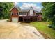 A brick home with a rear deck and screened-in porch is surrounded by lush greenery at 3648 Clark Hill Way, Buford, GA 30519