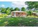 Spacious backyard with lush green grass and brick exterior, partially fenced, surrounded by mature trees at 1167 Sanders Dr, Morrow, GA 30260