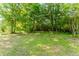 A spacious backyard area surrounded by lush greenery and trees, perfect for outdoor activities at 1167 Sanders Dr, Morrow, GA 30260