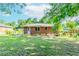 A single-story brick home is pictured with a large lawn and mature trees at 1167 Sanders Dr, Morrow, GA 30260