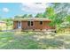 View of the home's brick exterior and grassy backyard with partial fence and mature trees providing shade at 1167 Sanders Dr, Morrow, GA 30260