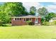 Traditional brick home with a lush green lawn and mature trees in a serene setting at 1167 Sanders Dr, Morrow, GA 30260