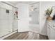 Bathroom with granite counters, white cabinetry, a glass-enclosed shower, and wood-look vinyl flooring at 11689 Mendenhall Ct, Hampton, GA 30228