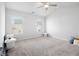 A calm bedroom offers neutral carpeting, a ceiling fan, and two windows allowing for plenty of natural light at 11689 Mendenhall Ct, Hampton, GA 30228