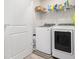 Bright laundry area featuring a white washer and dryer, overhead shelving and convenient access to the rest of the home at 11689 Mendenhall Ct, Hampton, GA 30228