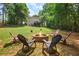 Scenic backyard with a charming fire pit, chairs, and a view of the home at 124 Hunters Mill Rd, Woodstock, GA 30188