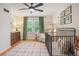 Cozy Bedroom with a crib, a dresser with changing table, a ceiling fan, and natural light at 124 Hunters Mill Rd, Woodstock, GA 30188