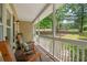 Relaxing front porch featuring rocking chairs, offering a tranquil outdoor space with views of the landscaped yard at 124 Hunters Mill Rd, Woodstock, GA 30188