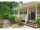 Welcoming front porch with classic white railings and stairs, perfect for enjoying the peaceful surroundings at 124 Hunters Mill Rd, Woodstock, GA 30188