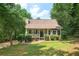 Charming single-Gathering home with a welcoming front porch and lush landscaping, creating a serene curb appeal at 124 Hunters Mill Rd, Woodstock, GA 30188