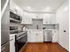 Modern kitchen featuring stainless steel appliances, white cabinets, and stylish backsplash at 2822 Waters Sw Rd, Atlanta, GA 30354