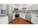 Modern kitchen featuring stainless steel appliances, white cabinets, and stylish backsplash at 2822 Waters Sw Rd, Atlanta, GA 30354
