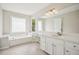 Bright bathroom featuring a dual vanity, tub, and a large mirror at 2907 Wickford Dr, Kennesaw, GA 30152